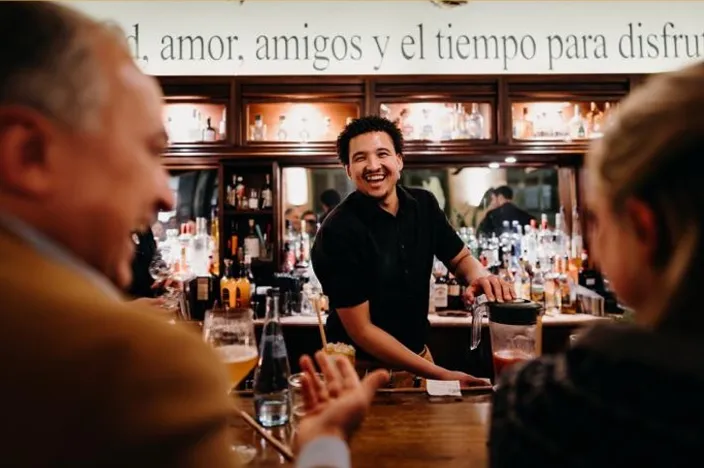 Barkeeper hinter dem Tresen im Gespräch mit Gästen bei Joe Peña's